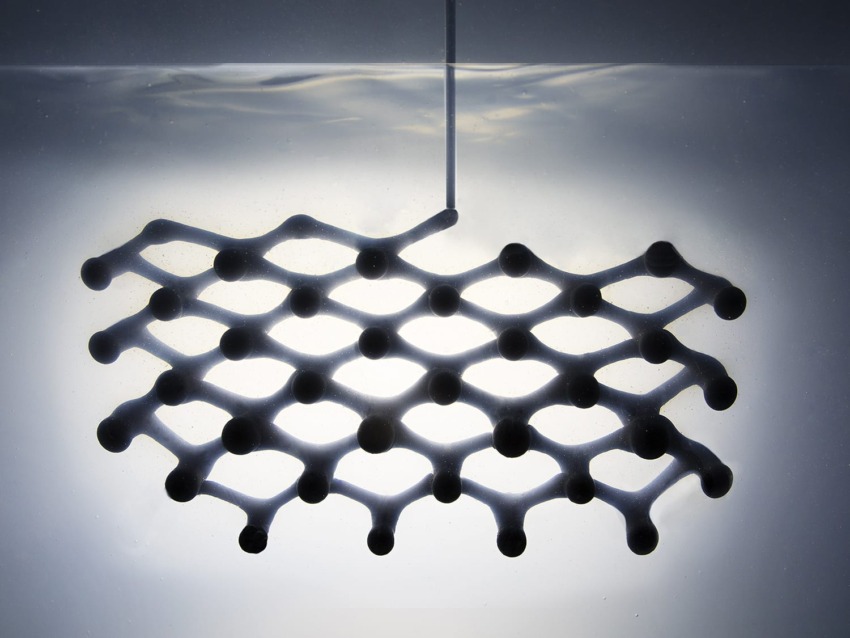 3D mesh structure partially submerged in water, with light casting geometric reflections above the surface.