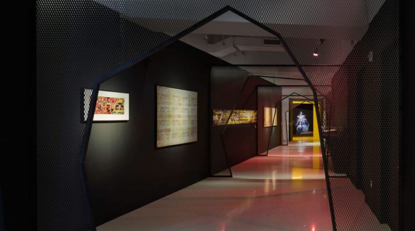 Art gallery interior with modern geometric archways, dark walls, colorful paintings, and a lit pathway.