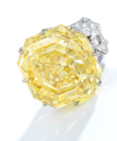 Large octagonal yellow diamond ring with intricate silver band on a white background.