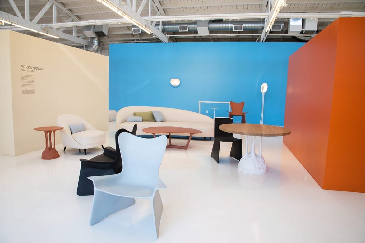 Modern furniture showroom with colorful walls featuring various contemporary chairs and tables on a polished white floor.