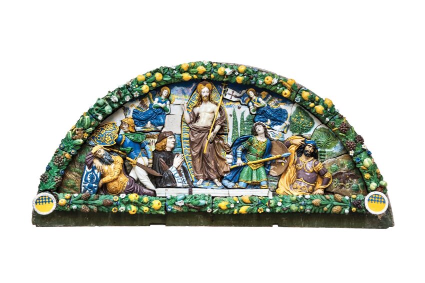 Colorful artistic depiction of religious figures in a semicircular ceramic relief with intricate details and floral accents.