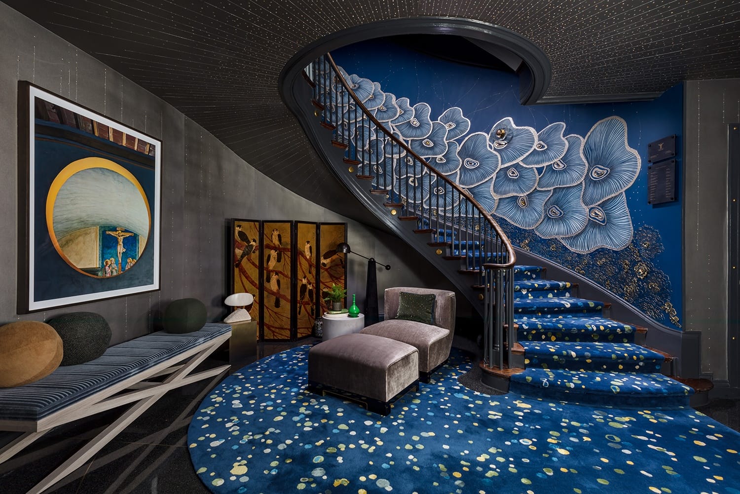 Luxurious interior with blue floral carpeted spiral staircase, abstract wall art, and contemporary furniture in a modern setting.