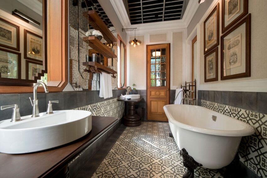 Luxurious bathroom showcasing a freestanding bathtub, patterned floor tiles, and elegant decor with framed art.