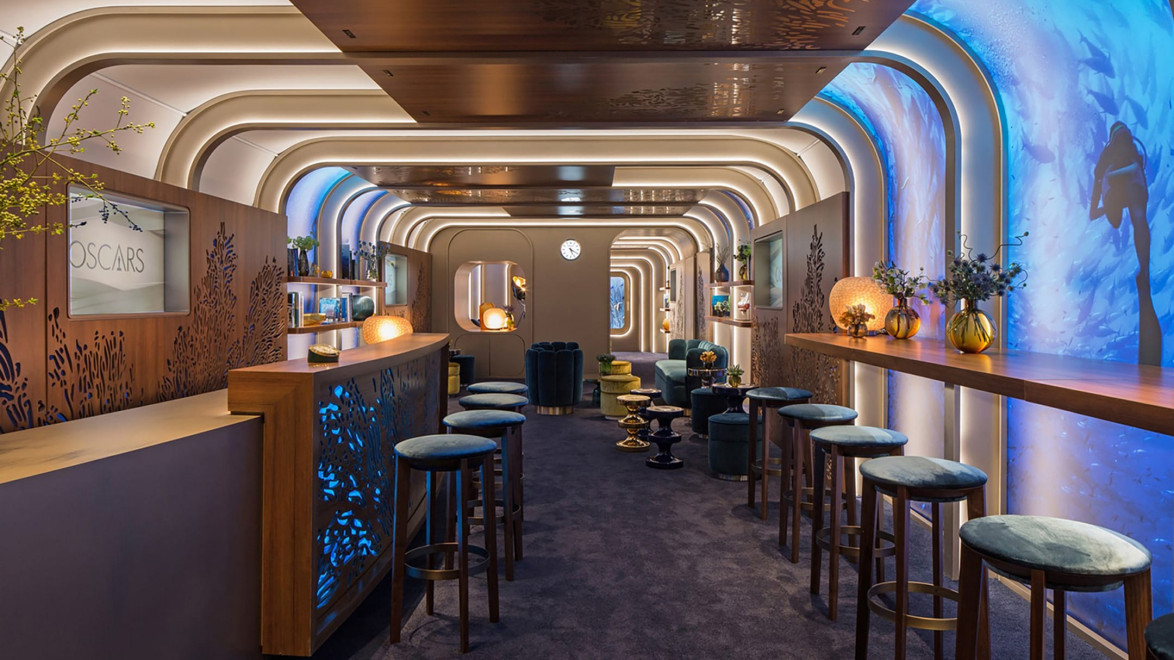 Stylish modern bar with wooden counters, high stools, and decorative lighting in an elegant, arched interior space.