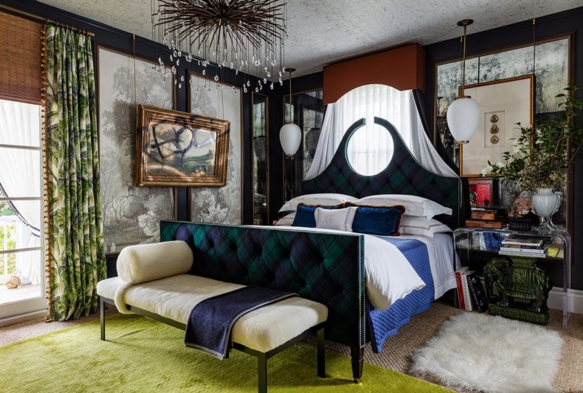 Elegant bedroom with plaid bedframe, unique chandelier, abstract art, and green accents, creating a cozy and stylish atmosphere.