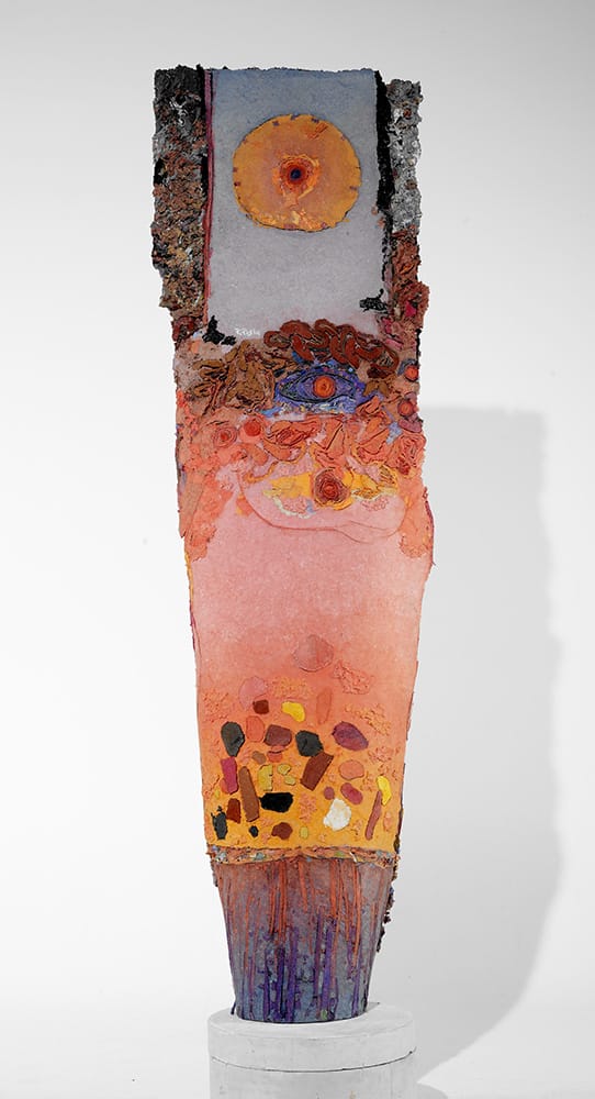 Colorful abstract sculpture with textured surfaces, featuring a mix of vibrant hues and intricate patterns on a pedestal.