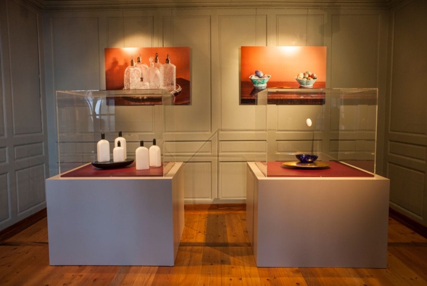 Exhibit featuring modern and traditional ceramic artworks displayed in a gallery with warm lighting.