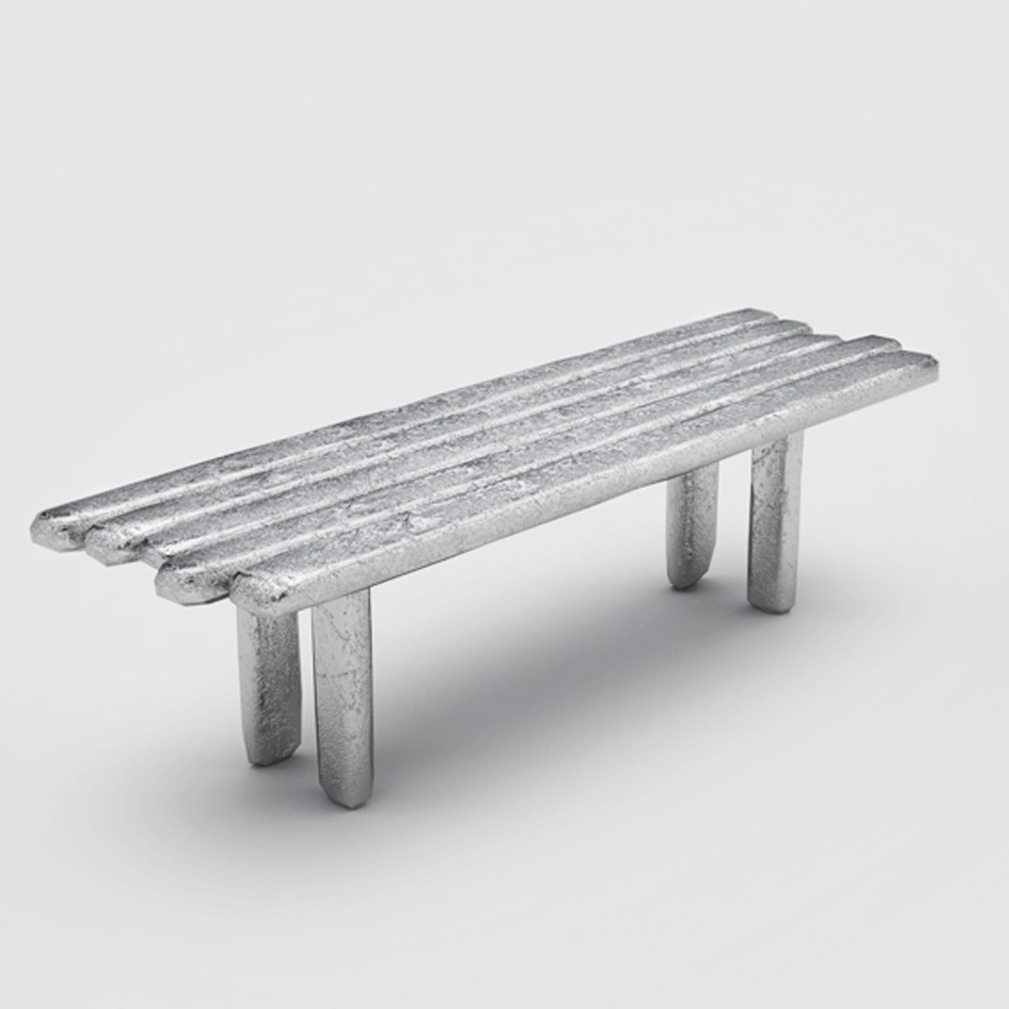 minimalist metallic bench with four cylindrical legs and a smooth surface on a plain white background