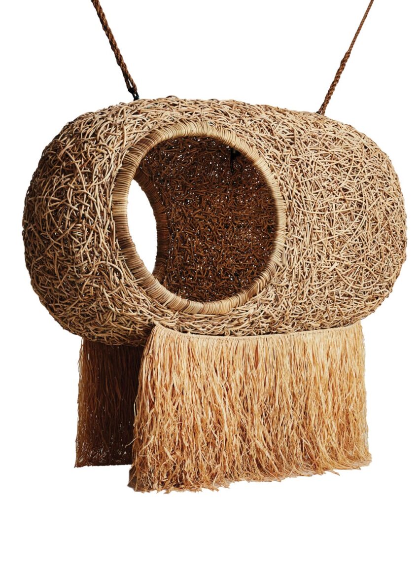 Woven rattan hanging chair with open oval design and fringe bottom, ideal for outdoor or indoor relaxation spaces