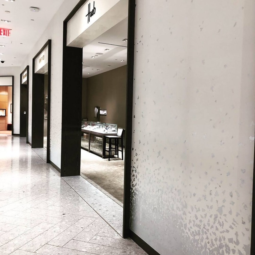Jewelry store entrance in a shopping mall with display cases and lit interior visible from the hallway.