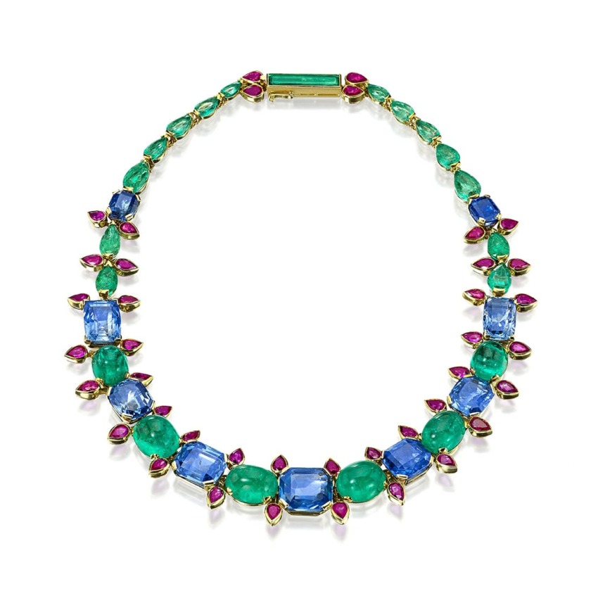 Colorful gemstone necklace with blue, green, and pink stones arranged in a symmetrical pattern on a white background.