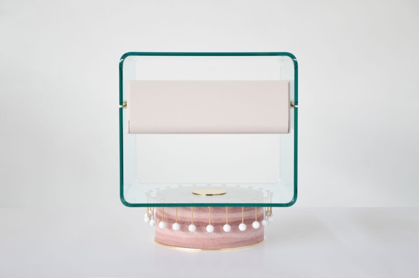 Modern glass and fabric table lamp with geometric shapes on a white surface.