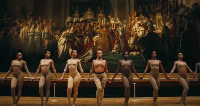 Group of dancers in front of a large historical painting in a museum setting.