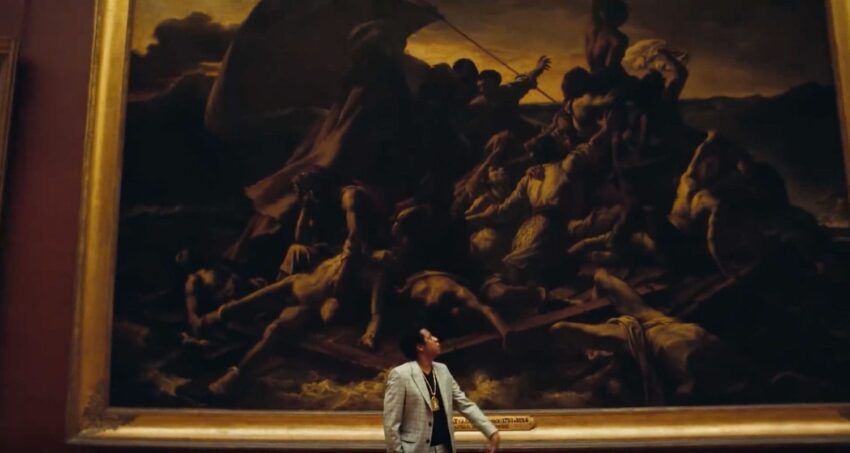 Man standing in front of a large painting depicting a dramatic historical scene with figures on a raft in a museum setting