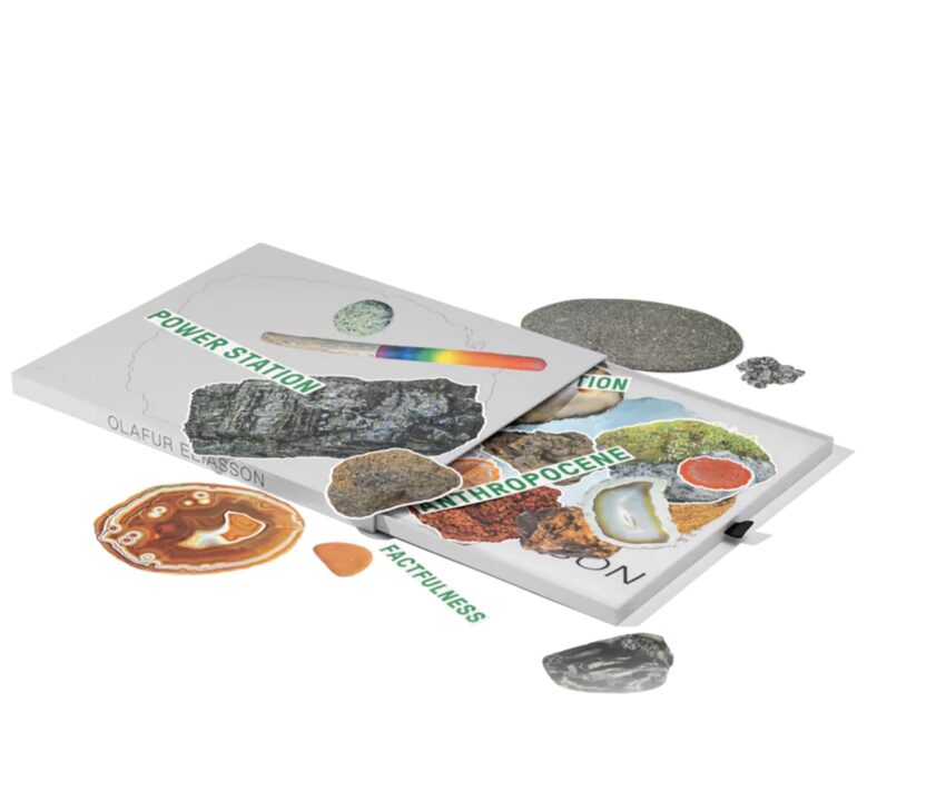 Book titled "Olafur Eliasson: Power Station," with vibrant, colorful art pieces and geological samples scattered around.