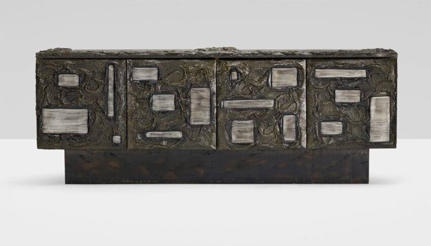 Rectangular abstract sculpture with a textured surface, featuring various raised and indented geometric shapes.