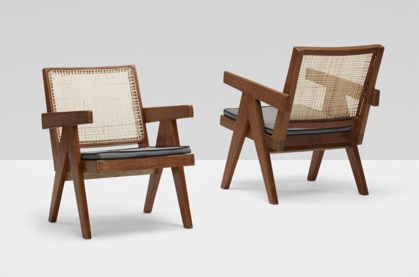 Two mid-century modern wooden chairs with woven cane backs and gray cushions, displayed against a plain background.