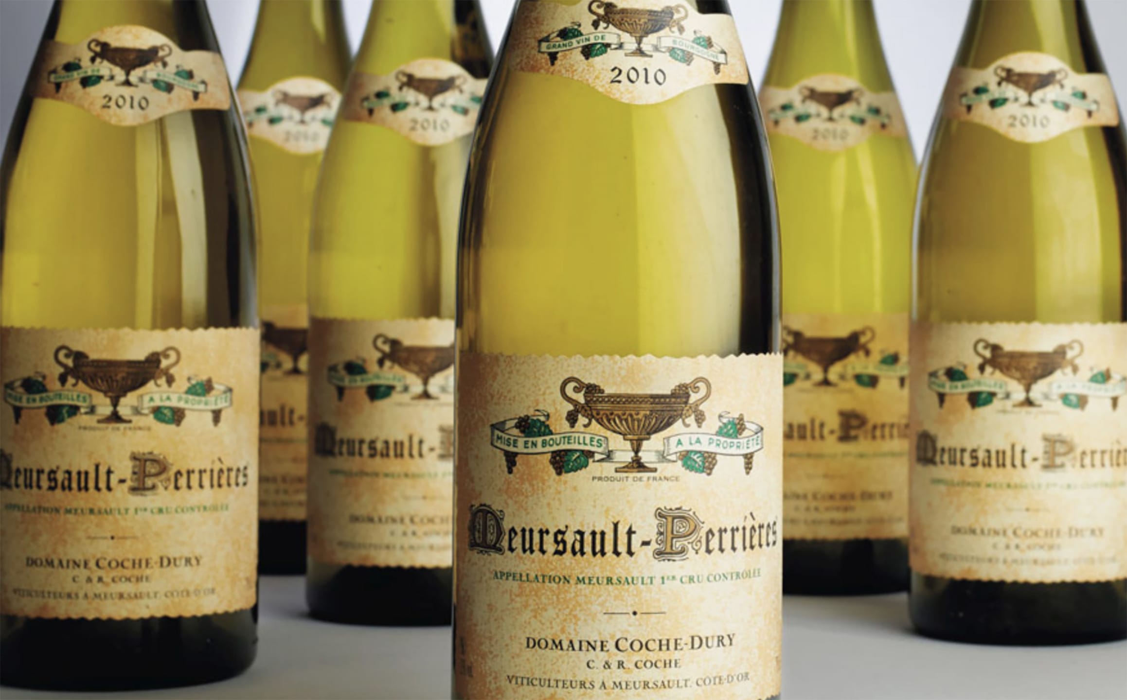 Bottles of Meursault-Perrières 2010 wine arranged in a group with detailed vintage labels in focus.