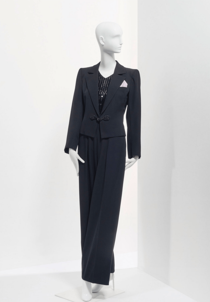 Mannequin wearing a chic black suit with a detailed top, posed against a minimalist white background.