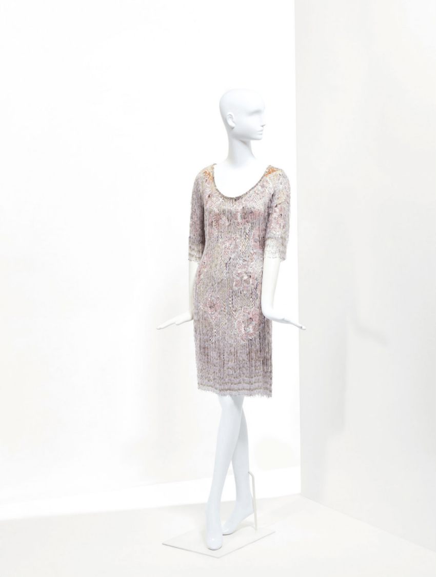 Mannequin wearing a short-sleeve lace dress with floral patterns, displayed against a minimalist white background.