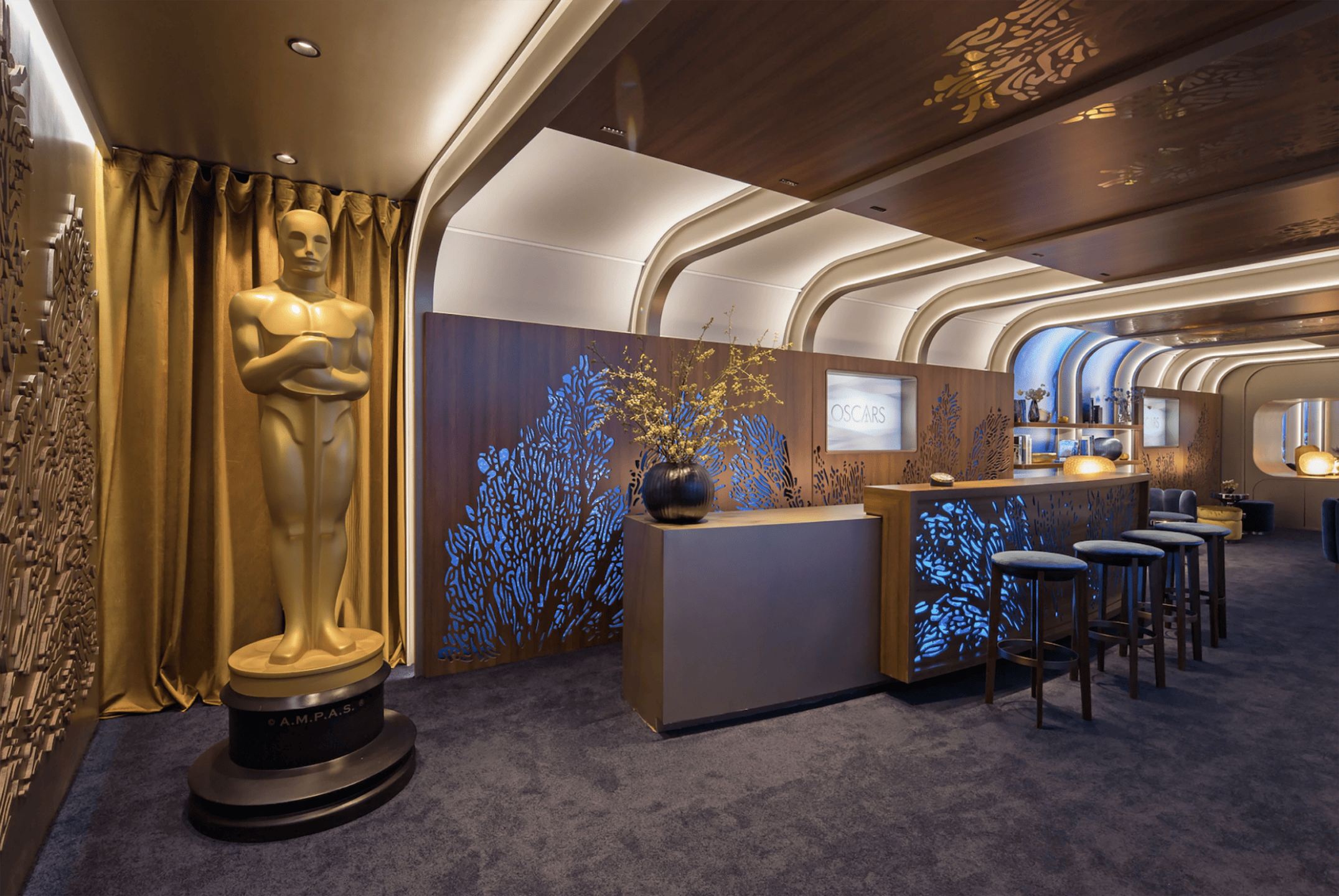 Luxurious room with Oscar statue, elegant bar, blue accents, decorative lights, and a plush carpeted floor.