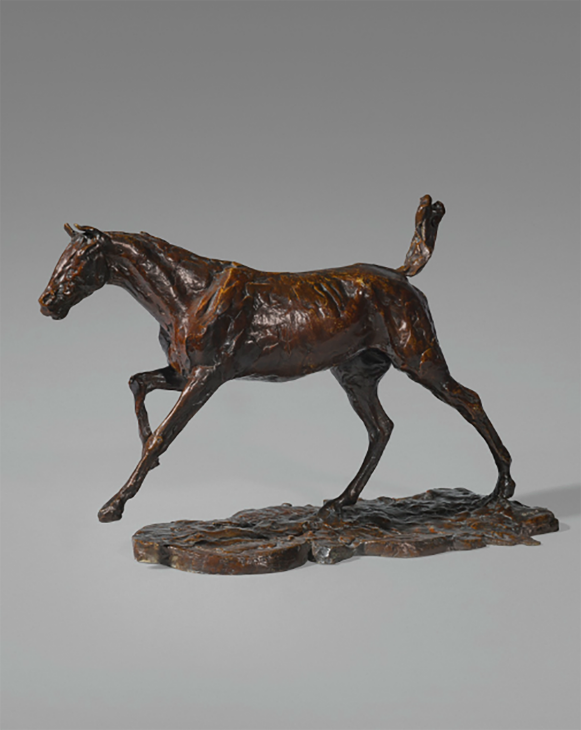 Bronze horse sculpture with detailed musculature and dynamic pose against a plain background.