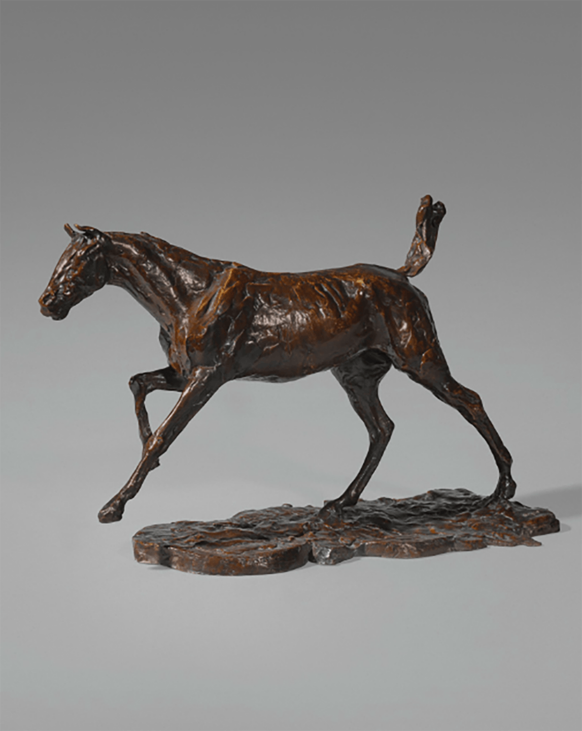 Bronze horse sculpture with detailed musculature and dynamic pose against a plain background.