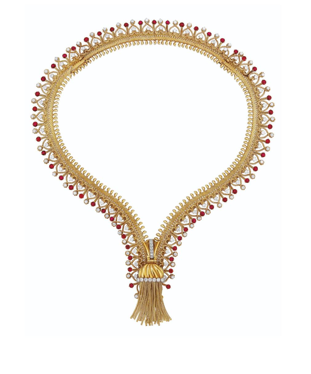 Gold necklace with intricate designs and red gemstone accents, featuring a tassel pendant at the bottom.