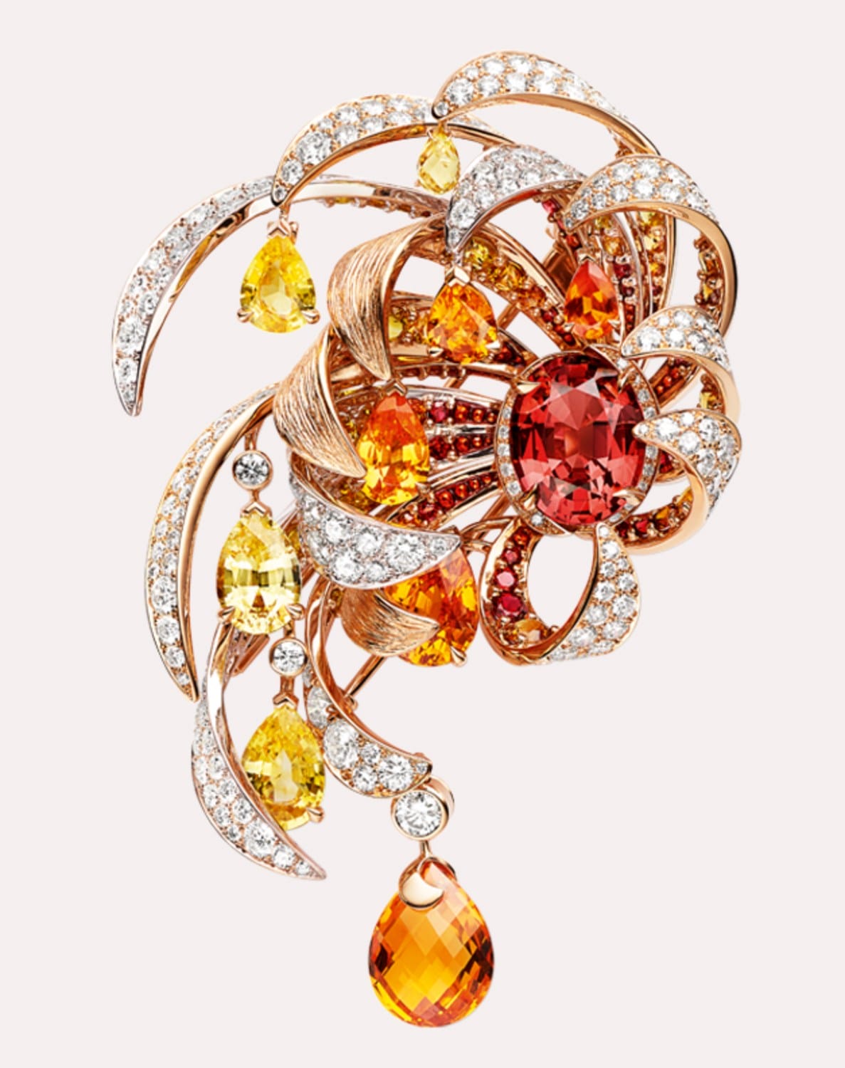 Intricate floral brooch with orange and yellow gemstones set in a swirling pattern, reflecting elegant craftsmanship.