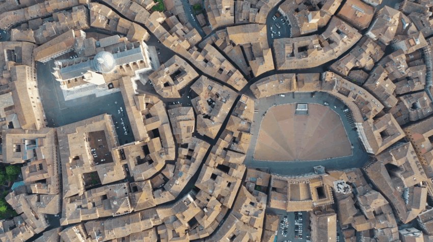 Aerial view of Siena's Piazza del Campo and surrounding medieval buildings, showcasing fan-shaped brick patterns.