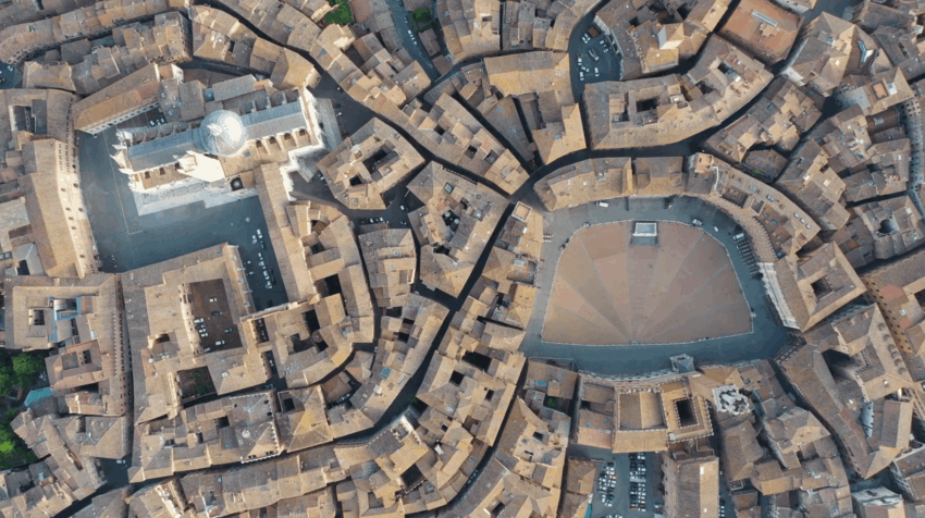 Aerial view of Siena's Piazza del Campo and surrounding medieval buildings, showcasing fan-shaped brick patterns.
