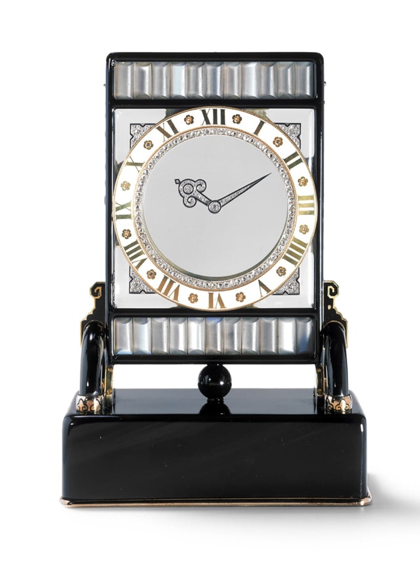 Art Deco vintage clock with gold accents and Roman numerals on a black stand.