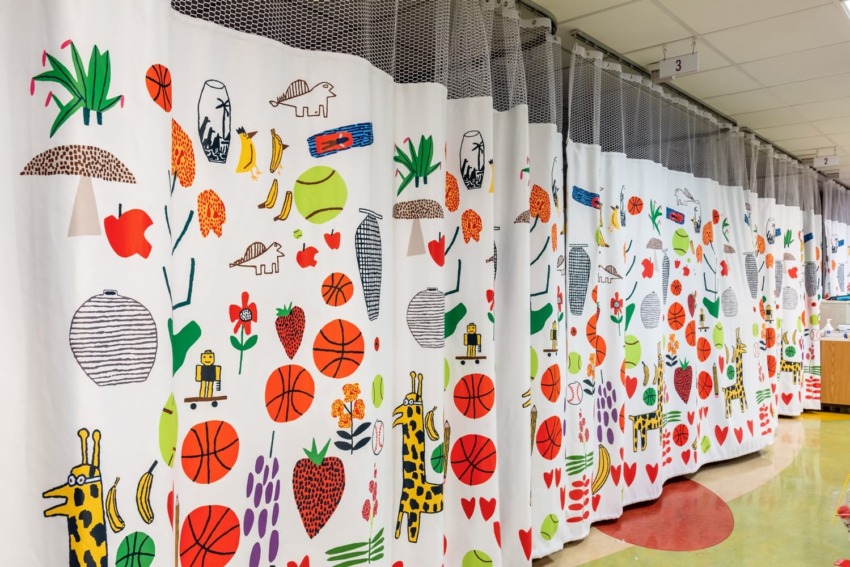 Colorful hospital curtains with playful drawings of animals, fruits, plants, basketballs, and various vibrant elements.