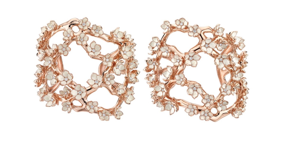 Intricate rose gold and pearl earrings with floral design on a white background.