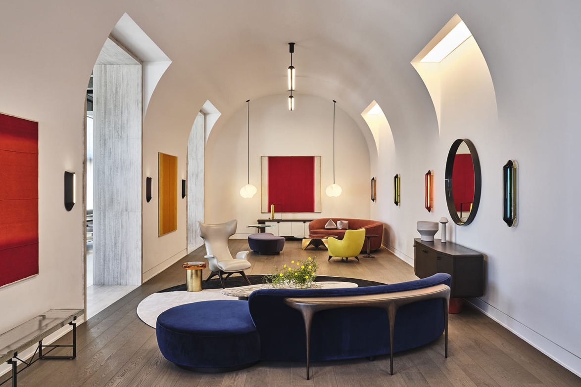 Modern living room with arched ceiling, colorful furniture, and large windows for natural light.