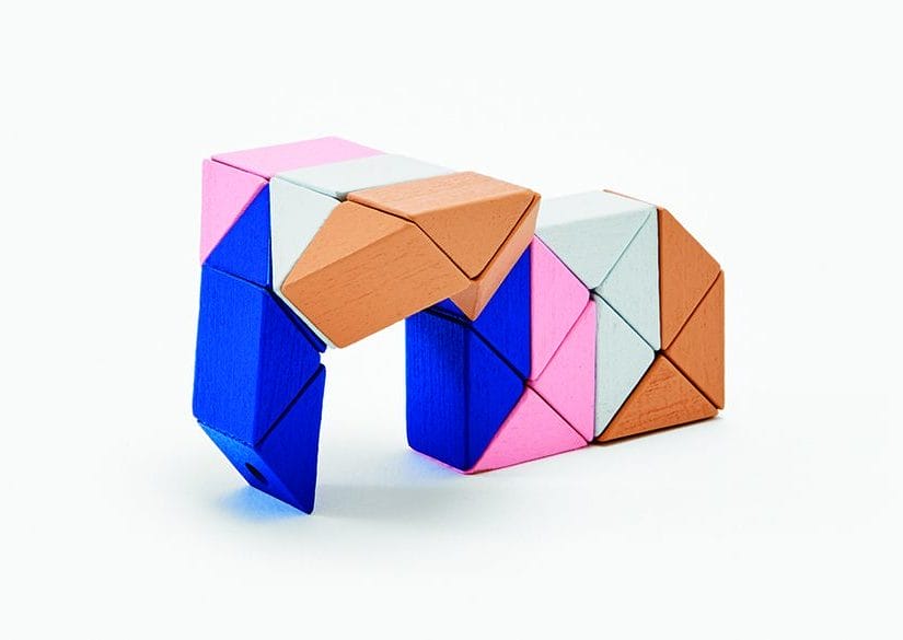 Colorful geometric wooden blocks arranged in an abstract shape on a white background.