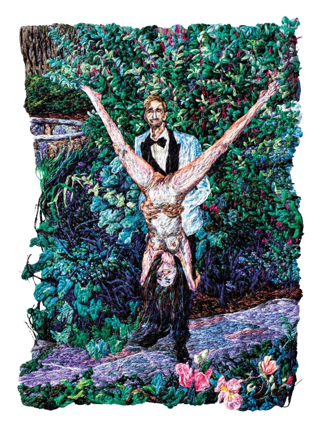 Man in black suit holding a woman upside down surrounded by lush greenery and pink flowers