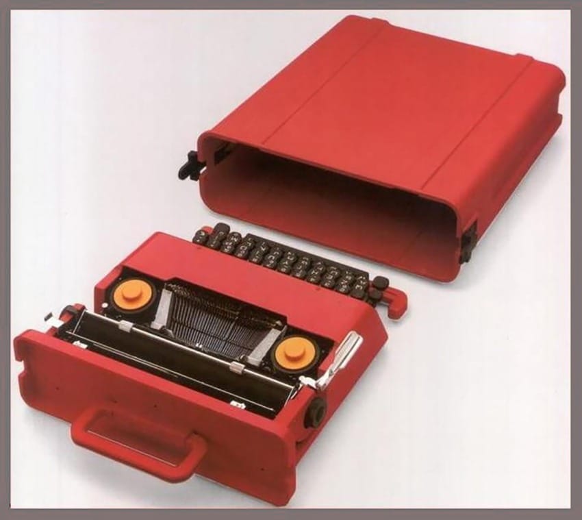 Vintage red typewriter with orange accents, separated from its matching red carrying case on a white background.