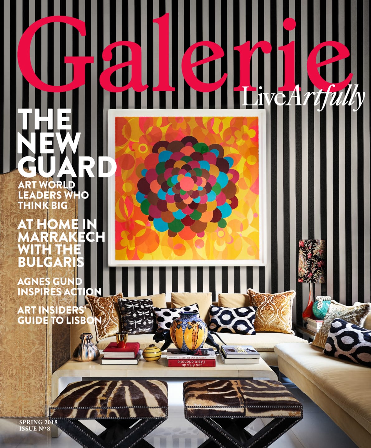 Magazine cover featuring a colorful abstract painting, patterned pillows on a sofa, and bold text about art and travel themes.