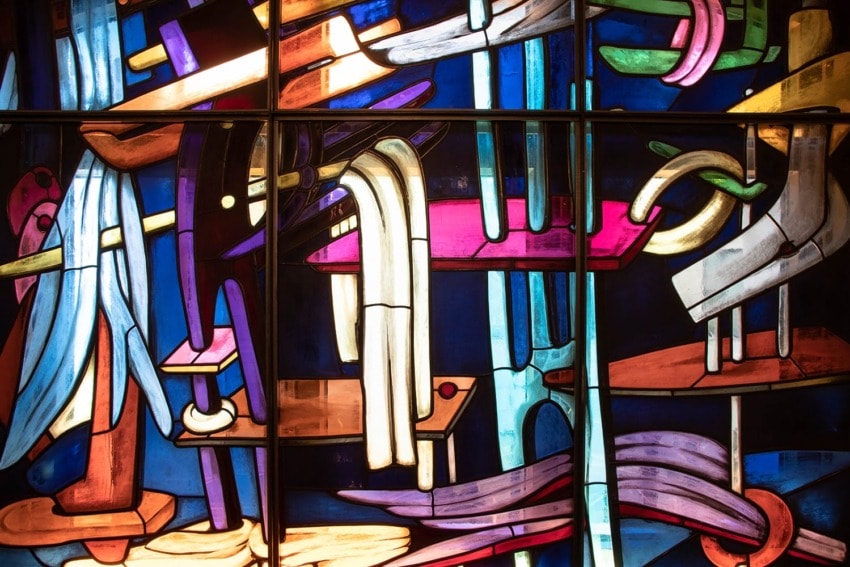 Colorful abstract stained glass window with varied geometric shapes and vivid hues, depicting a modern artistic design.