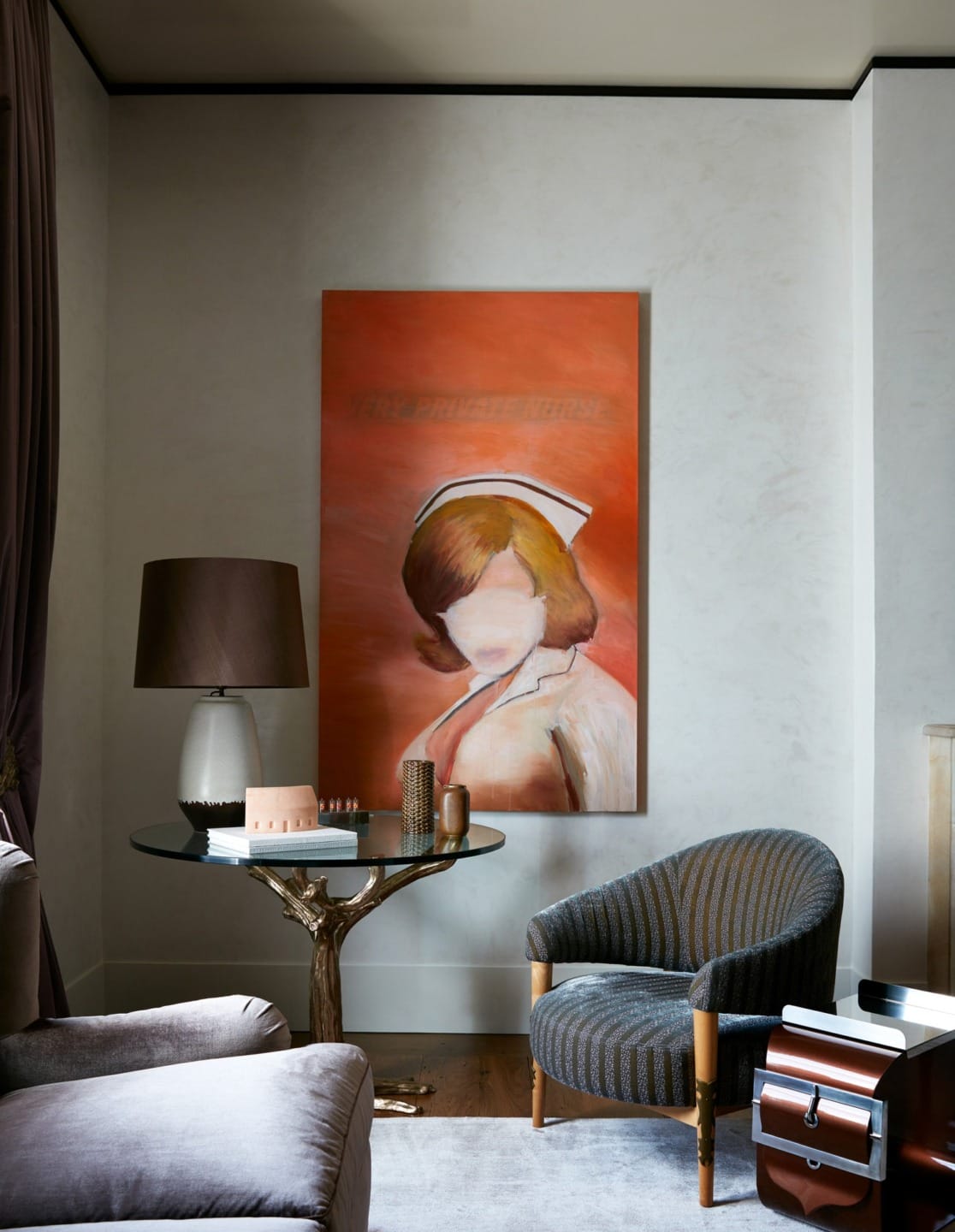 Painting of a woman with blurred face, wearing a hat, on an orange background hung in a modern, stylish living room.