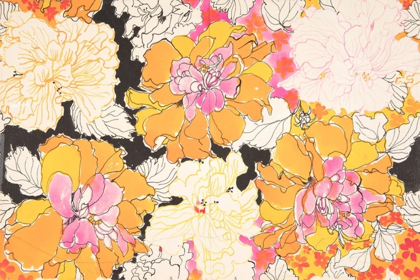 Colorful floral pattern with large pink, orange, and yellow flowers and intricate black and white outlines.