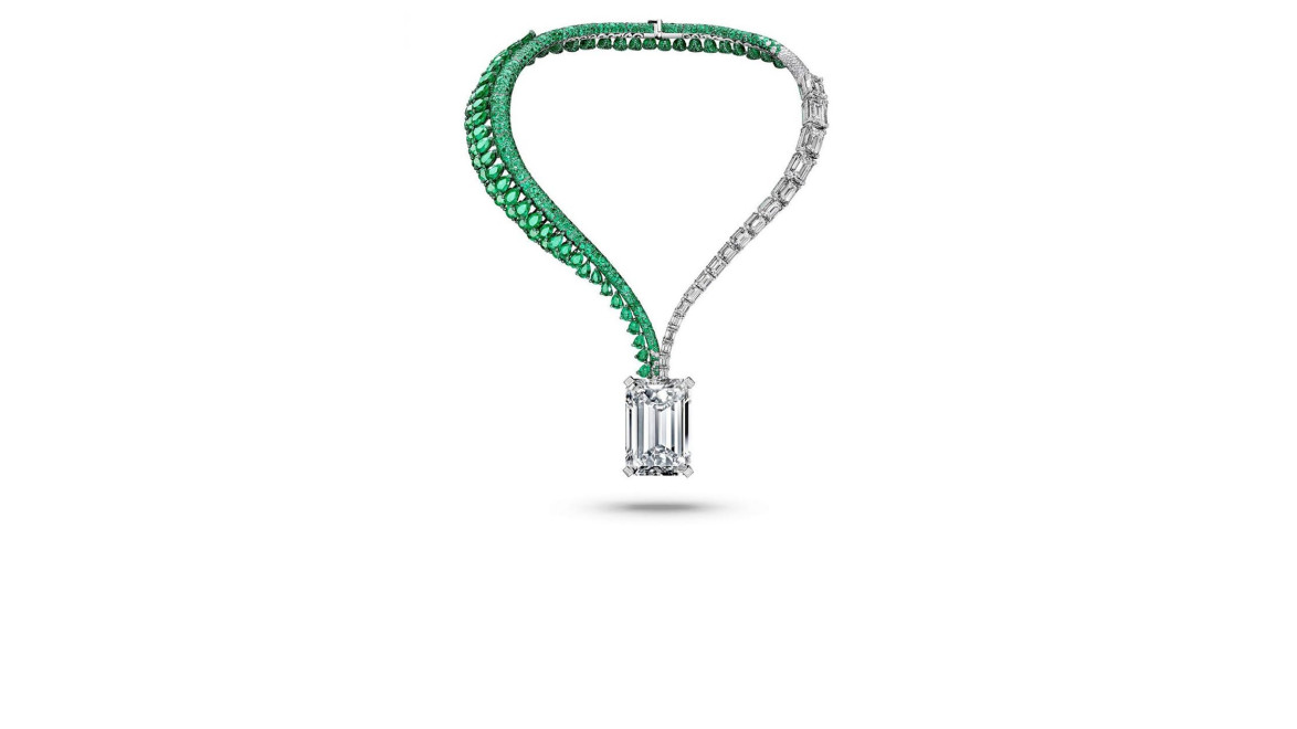 Emerald and diamond necklace with a large central gemstone suspended against a plain white background.