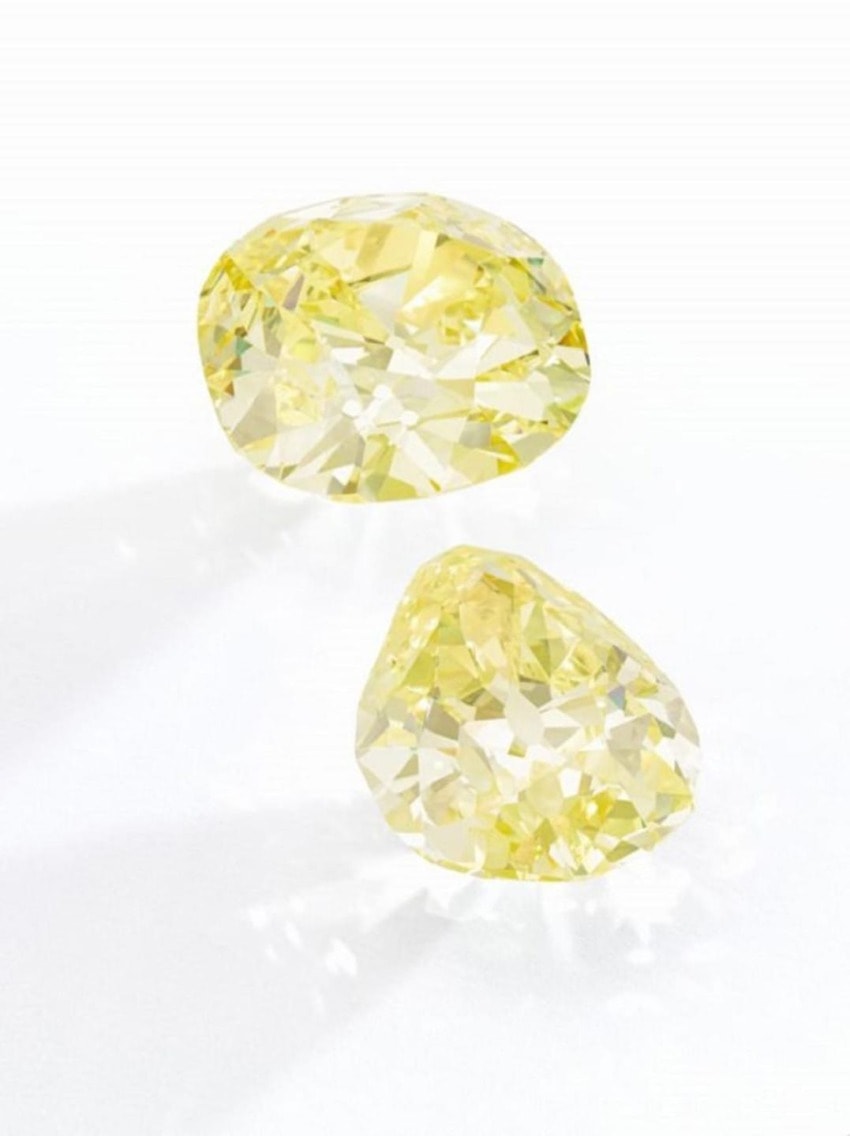 Two sparkling yellow diamonds placed on a white background, showcasing their brilliant cut and vibrant color.