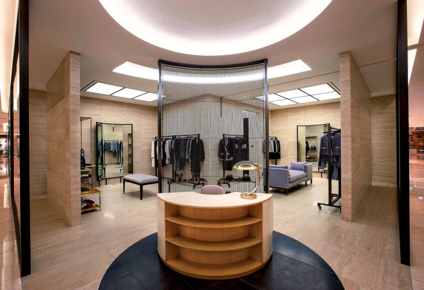 Luxurious modern clothing store interior with elegant furnishings, racks of stylish apparel, and soft lighting.