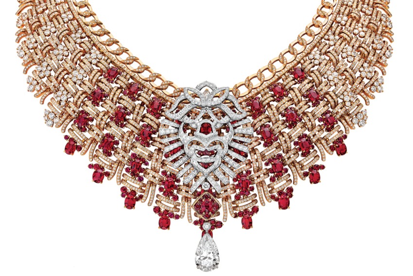 Lion-themed gold necklace with red gemstones and a teardrop pendant.