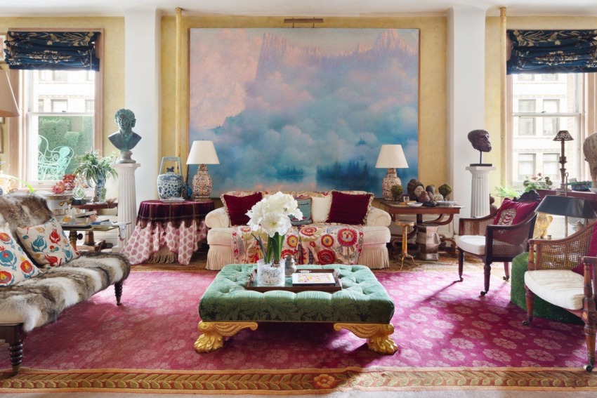 Elegant living room with eclectic decor, colorful artwork, patterned rugs, and plush seating arrangement.