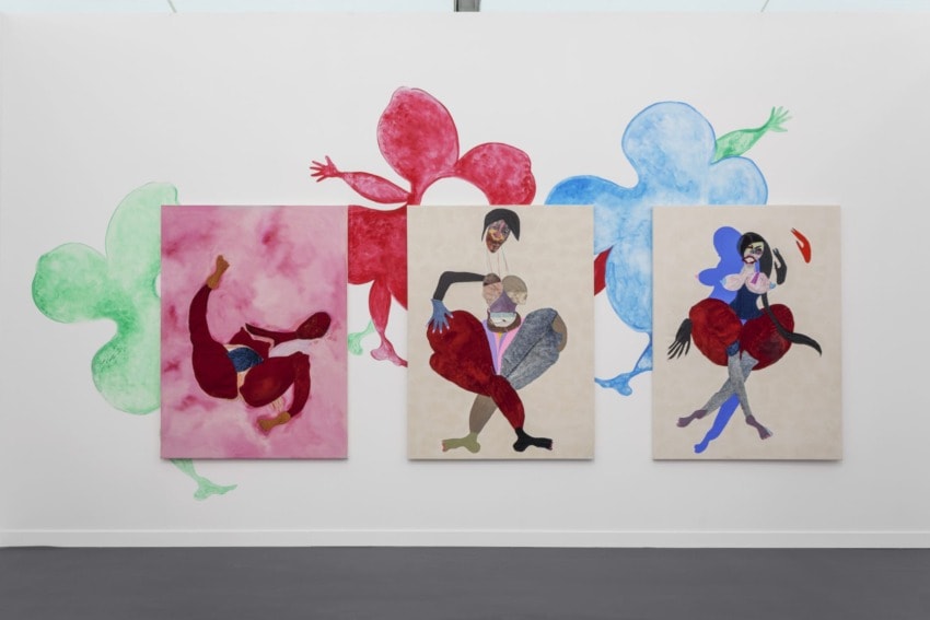 Three colorful abstract paintings on a gallery wall with playful shapes and vibrant colors.