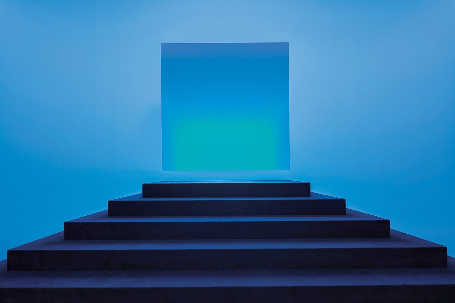 Blue cube above dark steps with a gradient light in a minimalist setting.