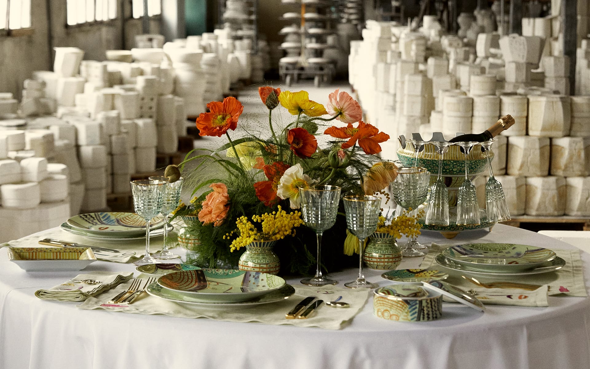 Elegant dining table with colorful floral centerpiece, surrounded by glassware and neatly arranged tableware in a restaurant setting.